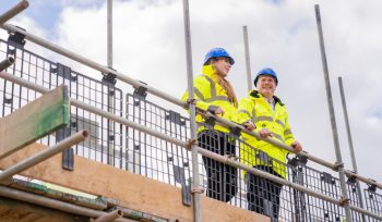 Keir Starmer and Angela Rayner dressed in construction gear, stood together in a construction site.