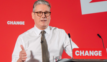 Keir Starmer standing behind a podium with the word "Change" written on it